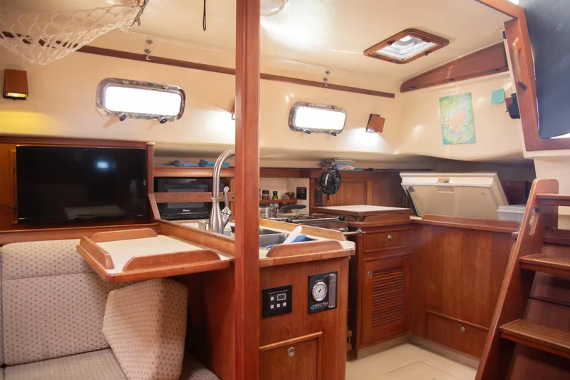 Slide: The Image of Interior of 1999 Island Packet 380 sailboat with cozy seating and wooden cabinetry. - 23