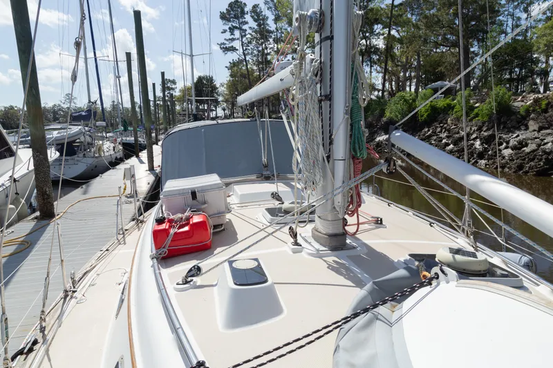 Slide: The Image of 1999 Island Packet 380 sailboat docked, showcasing deck and rigging under clear skies. - 26