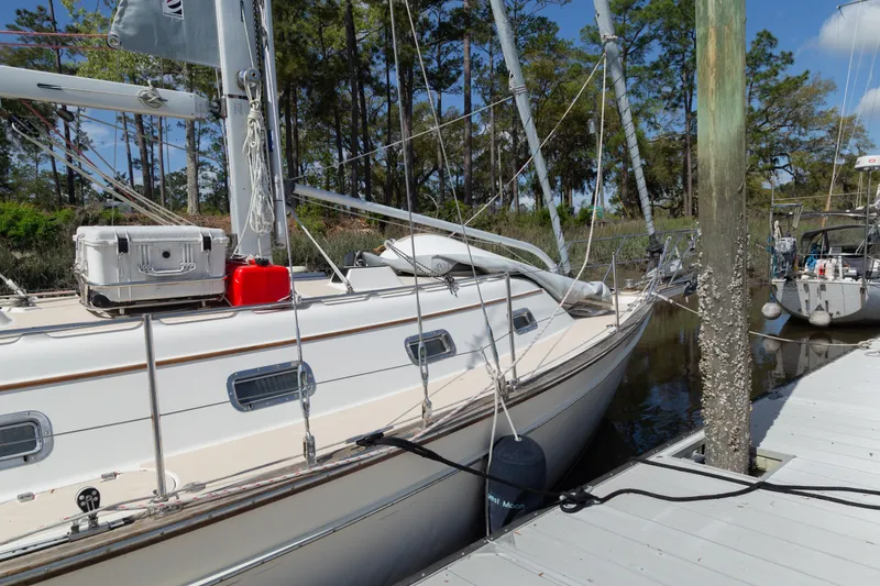 Slide: The Image of Sailboat Island Packet 380, 1999 model, docked at marina with trees in background. - 27