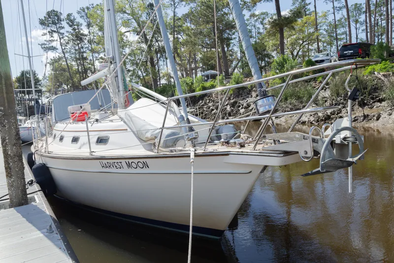 Slide: The Image of Sailboat "Harvest Moon," Island Packet 380, 1999 model, docked in a serene marina setting. - 28
