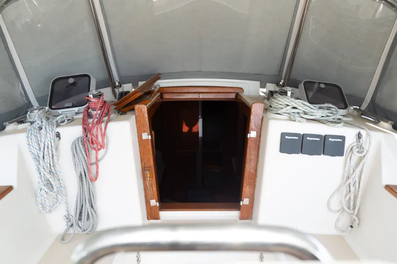 Slide: The Image of Island Packet 380 sailboat cockpit with ropes and open cabin door, 1999 model. - 31