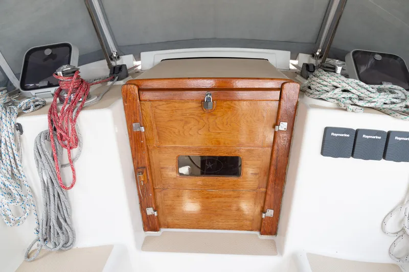 Slide: The Image of Island Packet 380 sailboat cockpit with wooden hatch and neatly coiled ropes, 1999 model. - 37
