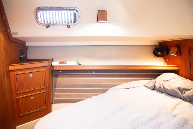 Slide: The Image of Cozy cabin interior of 1999 Island Packet 380 sailboat with wooden cabinetry and bedding. - 4