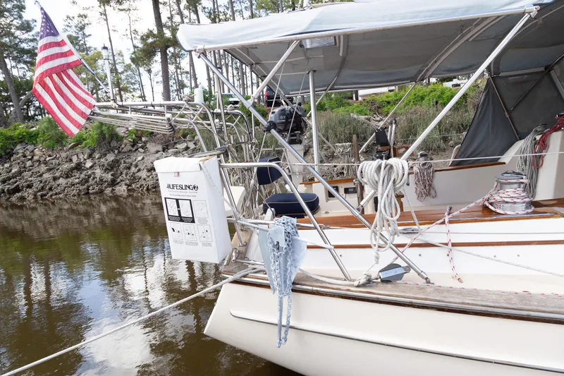 Slide: The Image of Sailboat docked by a riverbank, Island Packet 380, 1999 model, with American flag. - 40