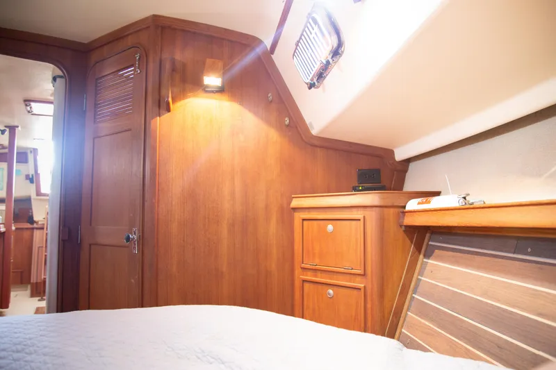 Slide: The Image of Cozy cabin interior of 1999 Island Packet 380 sailboat with wooden furnishings and soft lighting. - 5