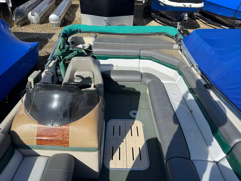 Slide: The Image of 1999 Sun Tracker Party Deck 21 boat interior with gray and green seating. - 10