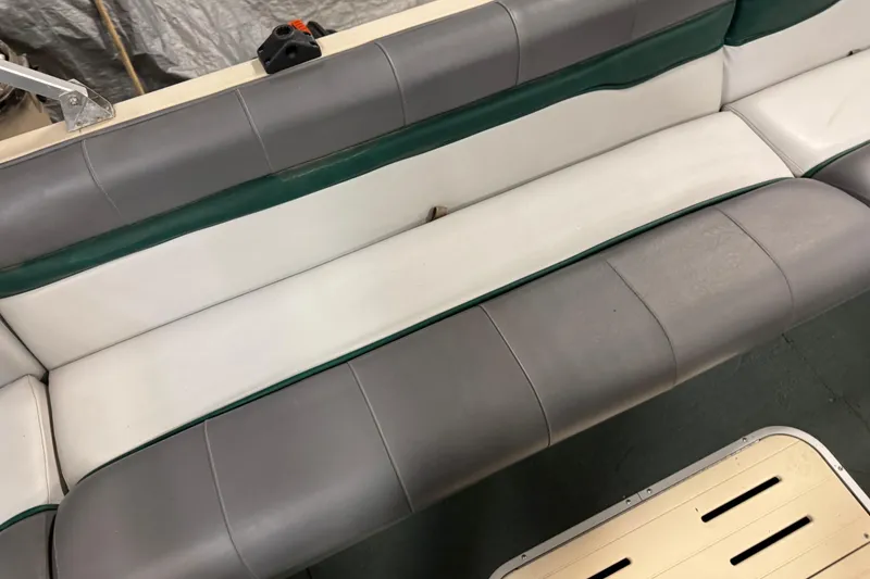 Slide: The Image of 1999 Sun Tracker Party Deck 21 boat seating, gray and white upholstery. - 16