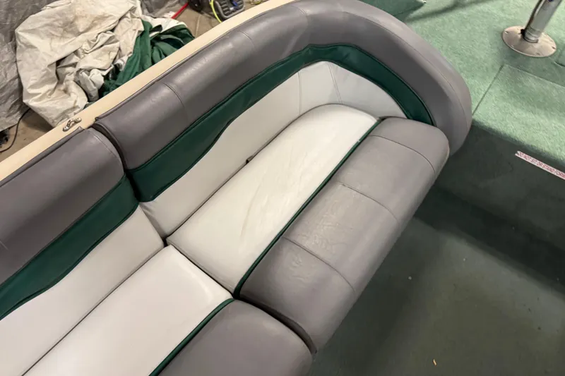 Slide: The Image of 1999 Sun Tracker Party Deck 21 boat seating with gray and green upholstery. - 17