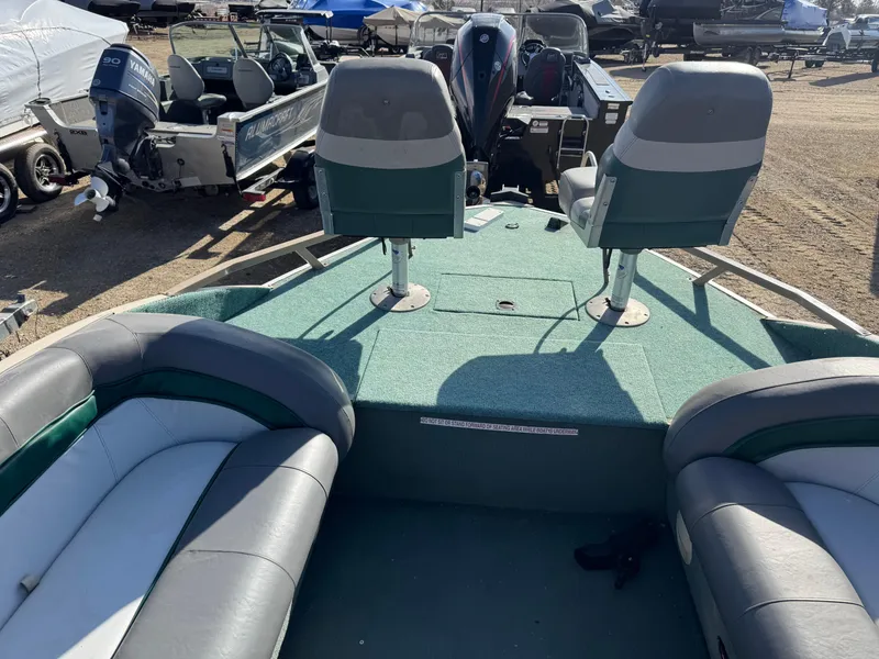 Slide: The Image of 1999 Sun Tracker Party Deck 21 boat with Mercury outboard motor in a garage. - 5