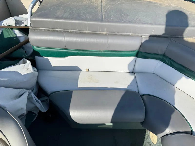 Slide: The Image of 1999 Sun Tracker Party Deck 21 boat seat with multicolored upholstery on green carpet. - 7