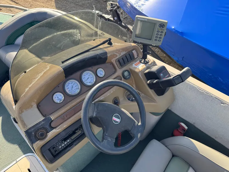 Slide: The Image of 1999 Sun Tracker Party Deck 21 boat interior with gray seating and green carpet. - 8