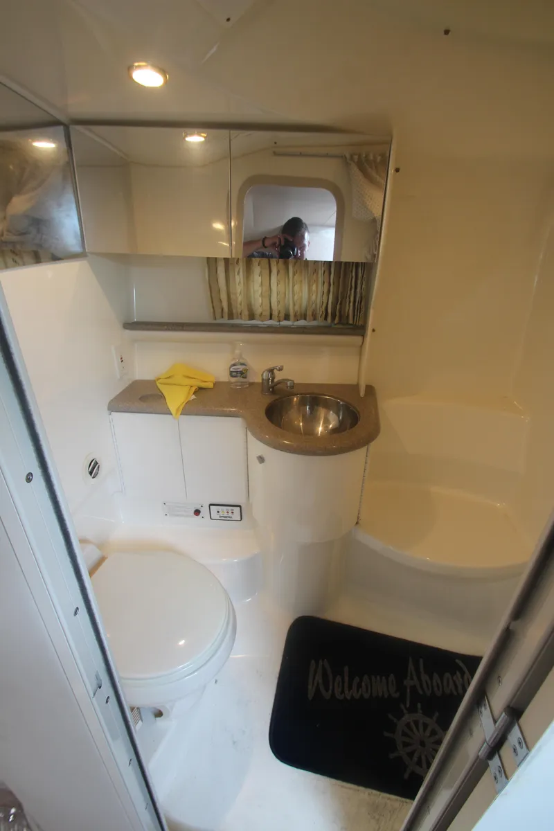 Slide: The Image of 2001 Formula 400 Super Sport boat bathroom with sink, toilet, and "Welcome Aboard" mat. - 21