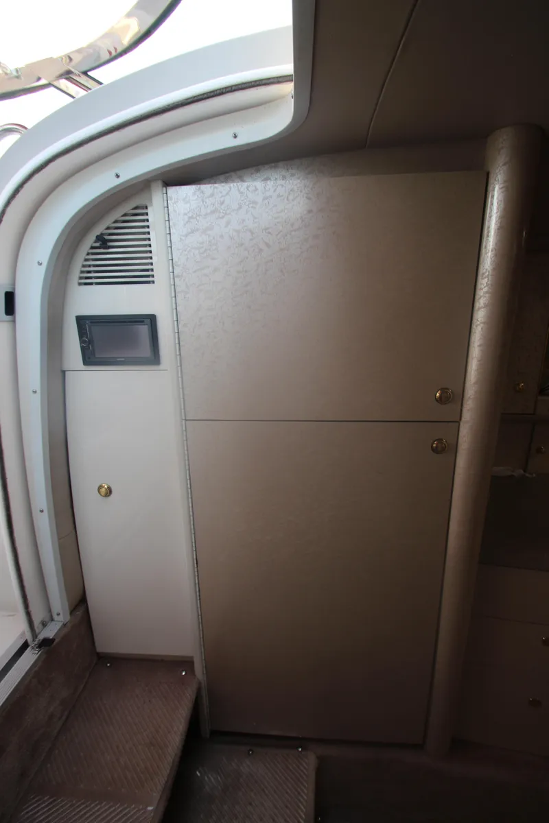 Slide: The Image of Interior of a 2001 Formula 400 Super Sport boat, featuring a compact storage cabinet. - 26