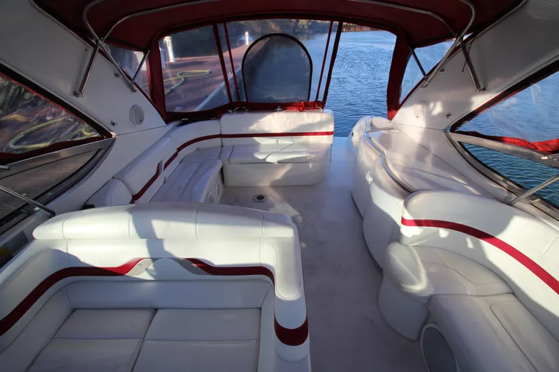 Slide: The Image of 2001 Formula 400 Super Sport boat interior with white and red seating, docked by the water. - 5