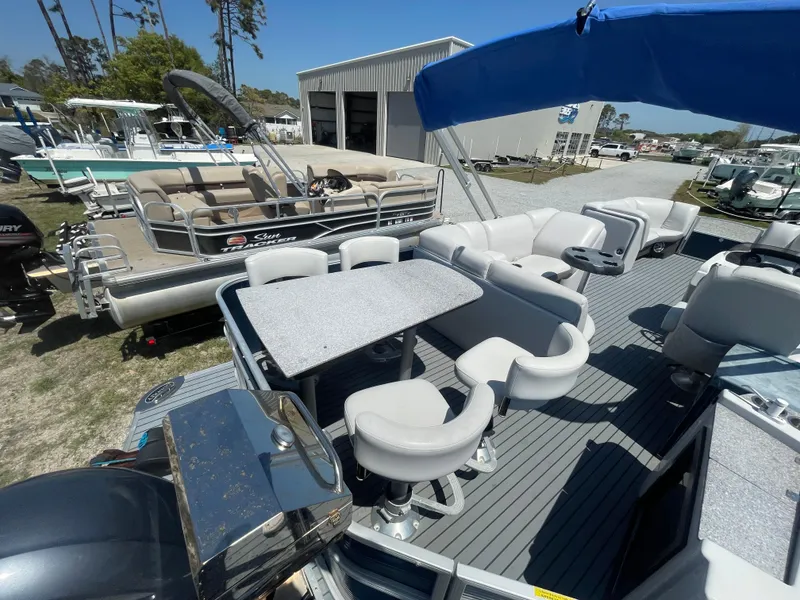 Slide: The Image of 2017 Godfrey 255 Sweetwater Premium pontoon boat with seating and table, docked outdoors. - 10