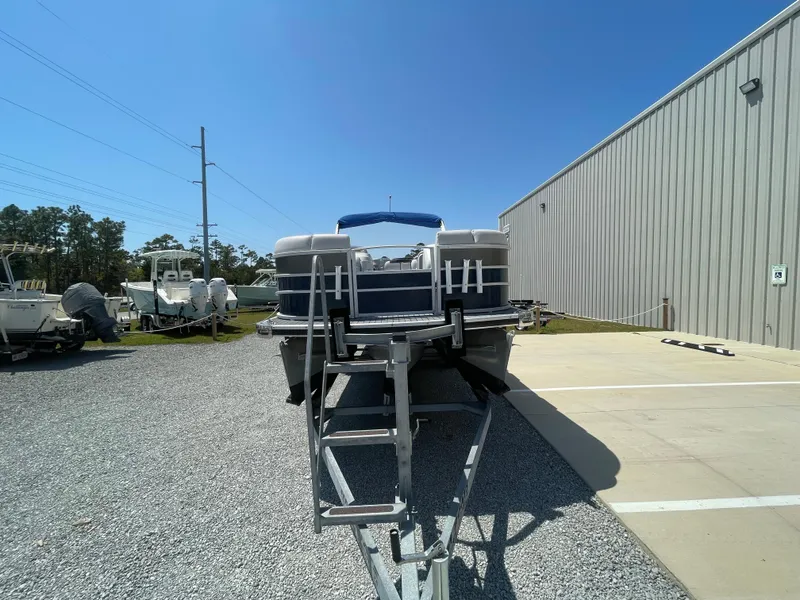 Slide: The Image of 2017 Godfrey 255 Sweetwater Premium pontoon boat on trailer, parked outdoors. - 2