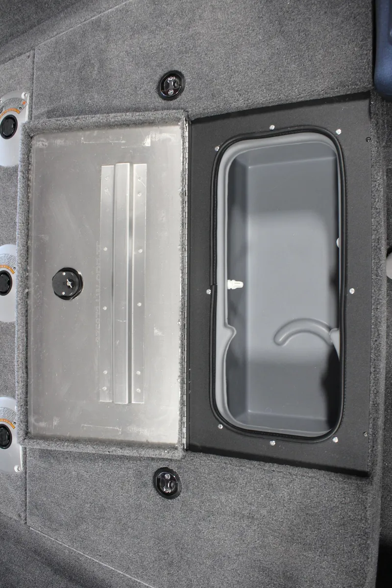 Slide: The Image of 2025 Tracker Pro Team 175 boat storage compartment with carpeted interior and secure latch. - 16