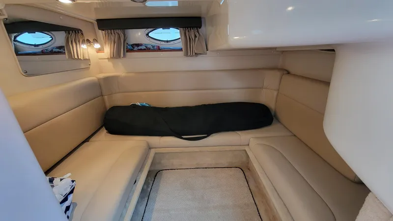 Slide: The Image of Interior of 2008 Monterey 315 Sport Yacht with beige seating and porthole windows. - 14