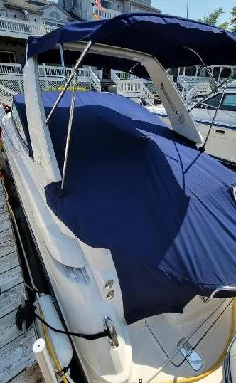 Slide: The Image of 2008 Monterey 330 Sport Yacht with blue cover docked at marina. - 2