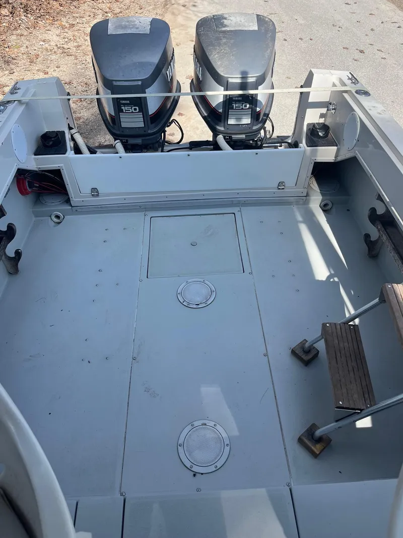 Slide: The Image of 1989 Wellcraft 250 Sportsman boat deck with dual 150 HP outboard engines. - 11