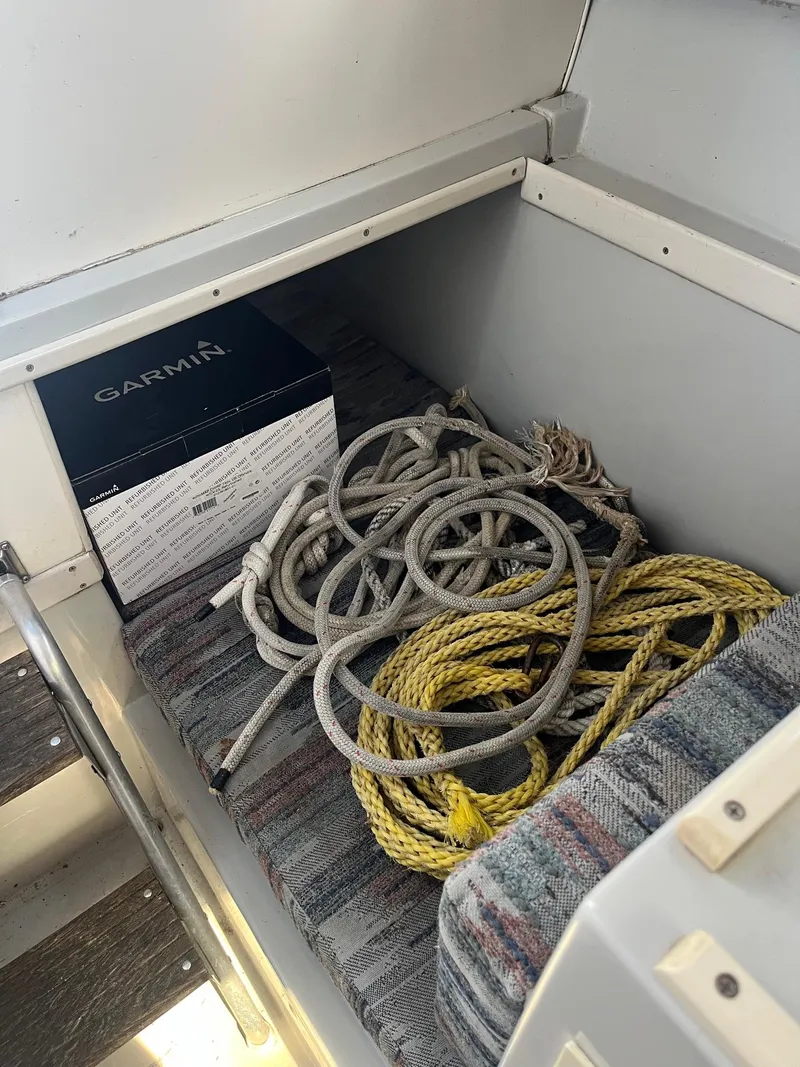 Slide: The Image of Storage compartment in 1989 Wellcraft 250 Sportsman boat with ropes and Garmin box. - 6