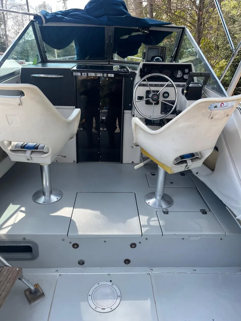 Slide: The Image of 1989 Wellcraft 250 Sportsman boat cockpit with dual white seats and steering wheel. - 9