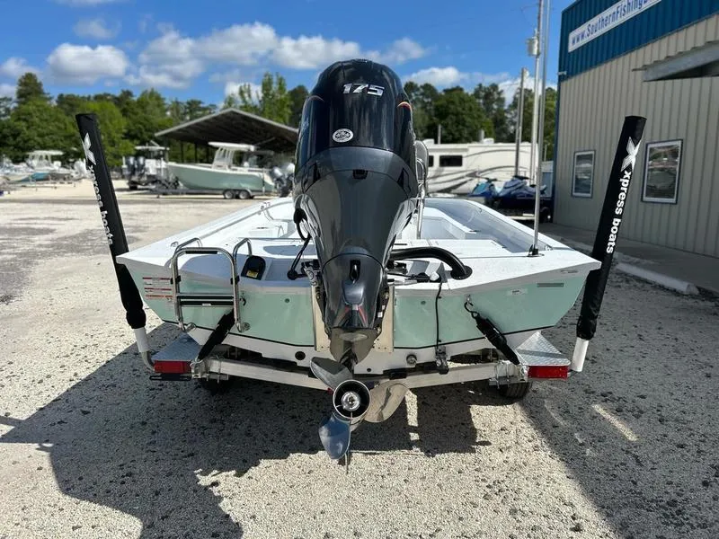 Slide: The Image of 2025 Xpress H22B boat with 175 HP engine, parked outdoors near a building. - 5