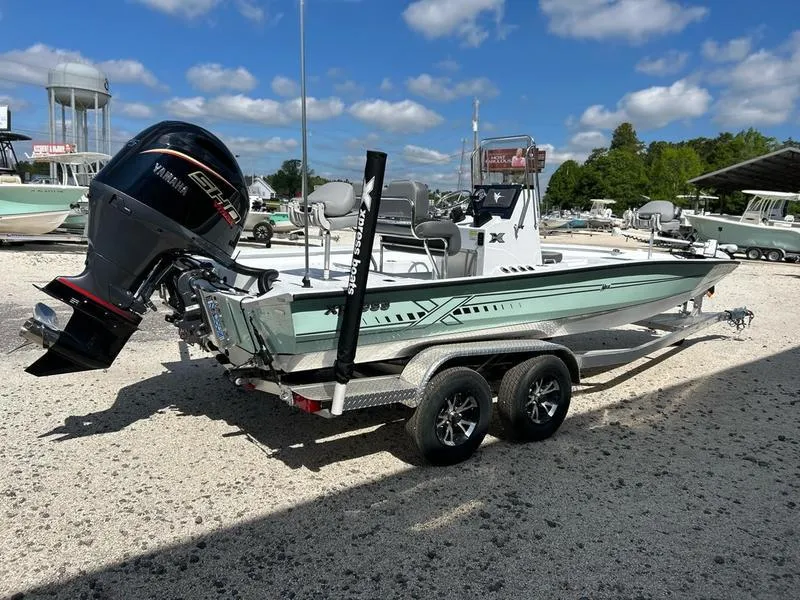Slide: The Image of 2025 Xpress H22B boat on trailer with Yamaha engine, parked outdoors under blue sky. - 6