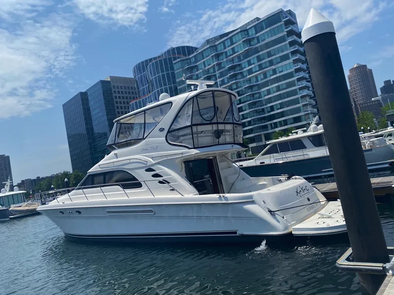 Slide: The Image of 2002 Sea Ray 56 Sedan Bridge yacht docked in urban marina with modern buildings. - 1