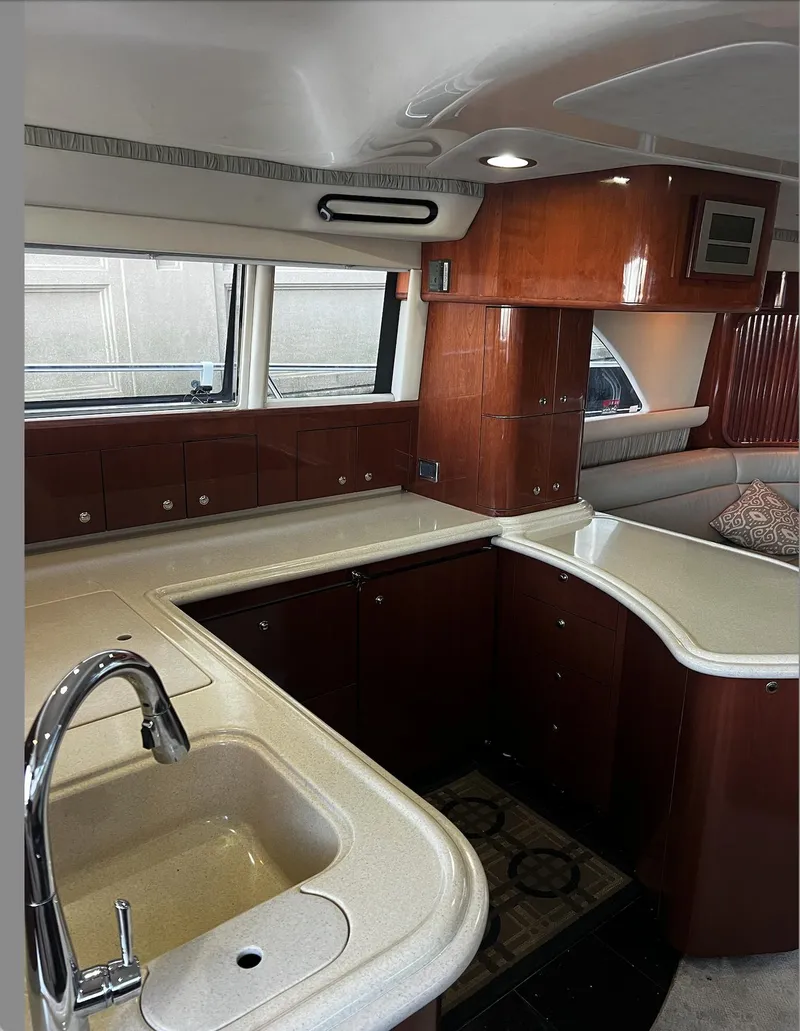 Slide: The Image of 2002 Sea Ray 56 Sedan Bridge yacht kitchen with wood cabinetry and modern fixtures. - 15