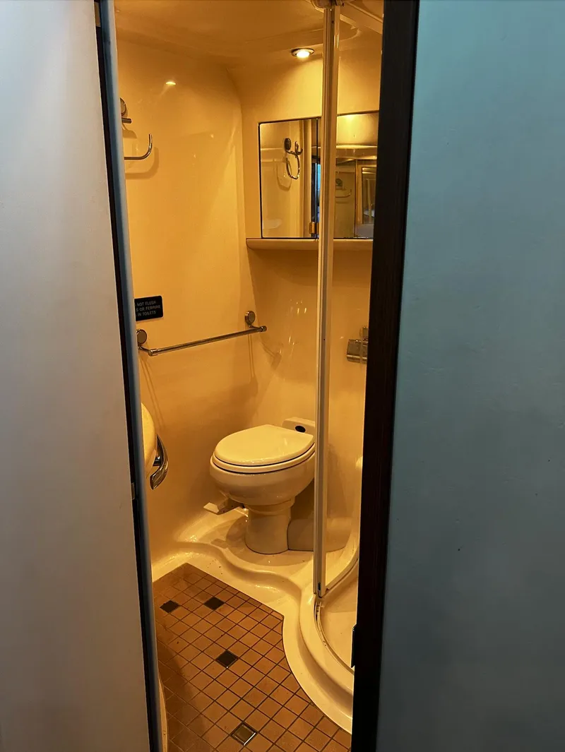 Slide: The Image of Compact bathroom in 2002 Sea Ray 56 Sedan Bridge yacht with shower and toilet. - 26