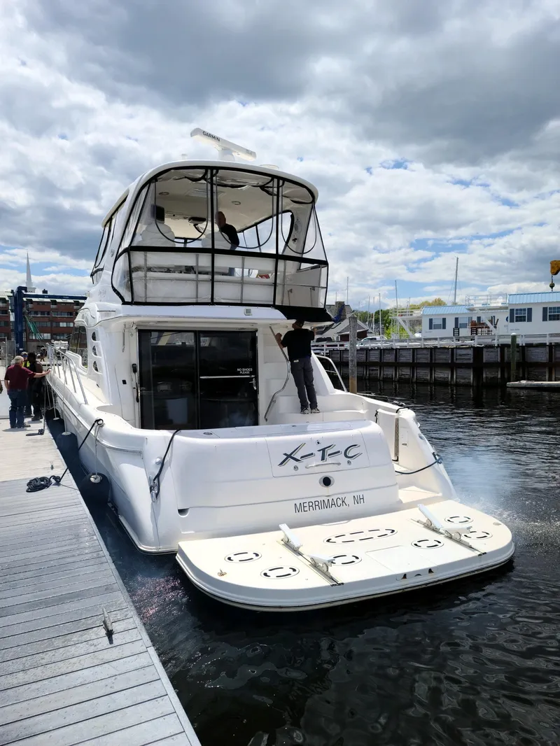 Slide: The Image of 2002 Sea Ray 56 Sedan Bridge yacht docked at marina under cloudy sky. - 4
