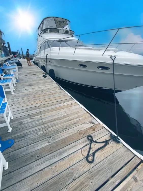 Slide: The Image of 2002 Sea Ray 56 Sedan Bridge yacht docked under a bright blue sky. - 5