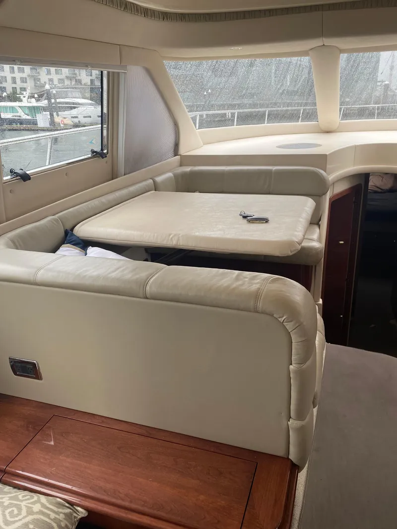 Slide: The Image of Interior of 2002 Sea Ray 56 Sedan Bridge with beige seating and table. - 8