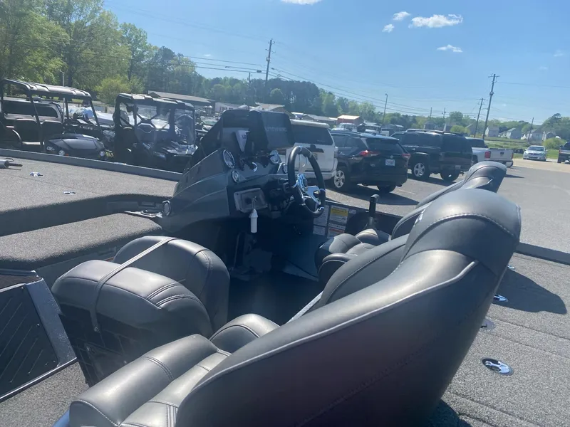 Slide: The Image of 2022 Nitro Z20 Pro boat interior with steering wheel and seats in a parking lot. - 6