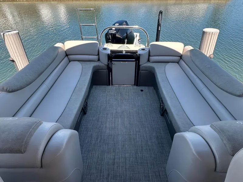 Slide: The Image of 2020 Avalon Catalina Platinum Quad Lounger boat interior with gray seating on calm water. - 11