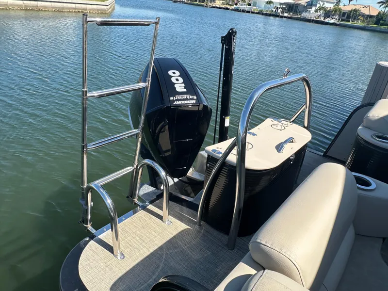 Slide: The Image of 2020 Avalon Catalina Platinum Quad Lounger boat with powerful engine and swim ladder on a serene lake. - 4