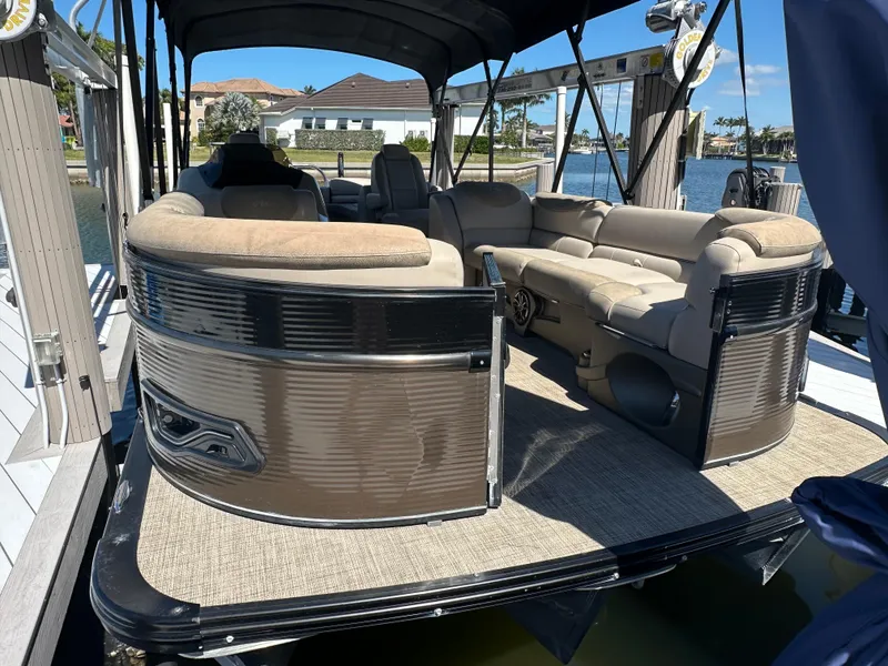 Slide: The Image of 2020 Avalon Catalina Platinum Quad Lounger boat docked, featuring spacious seating and elegant design. - 7