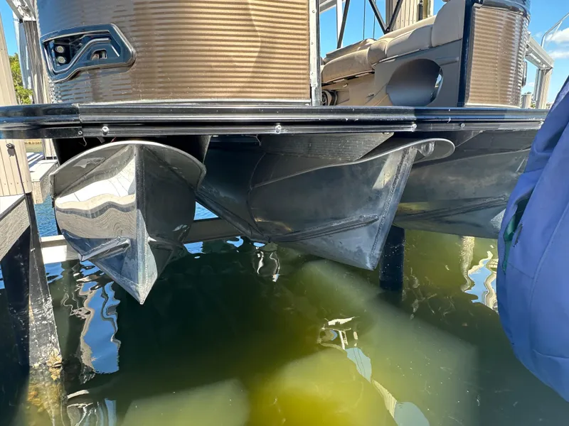Slide: The Image of 2020 Avalon Catalina Platinum Quad Lounger pontoon boat on water, showcasing pontoons and deck. - 8