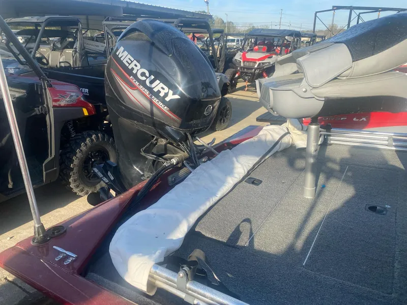 Slide: The Image of 2018 Tracker Pro 170 boat with Mercury outboard motor, parked near off-road vehicles. - 7