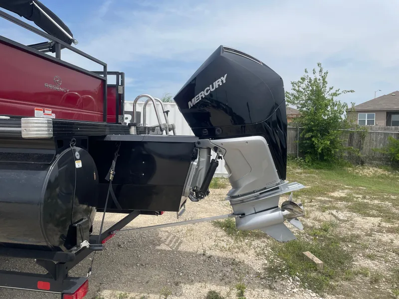 Slide: The Image of 2023 Regency 250DL3 boat with Mercury outboard motor, parked outdoors. - 3