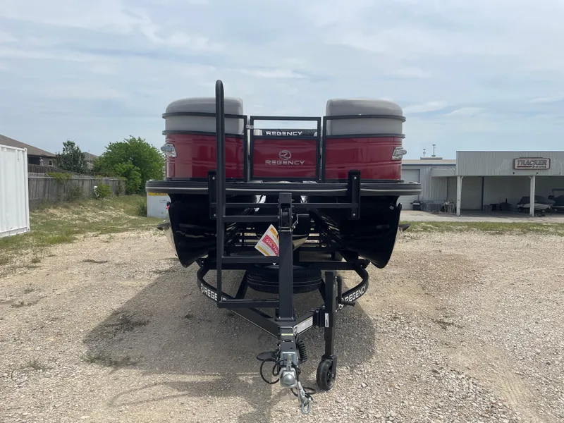Slide: The Image of 2023 Regency 250DL3 pontoon boat on trailer, rear view, parked outdoors. - 7
