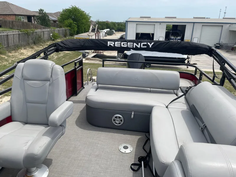 Slide: The Image of 2023 Regency 250DL3 pontoon boat interior with gray seating and open deck layout. - 15