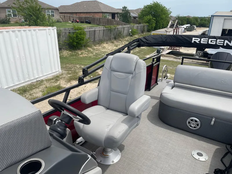 Slide: The Image of 2023 Regency 250DL3 pontoon boat with plush seating and steering console. - 16