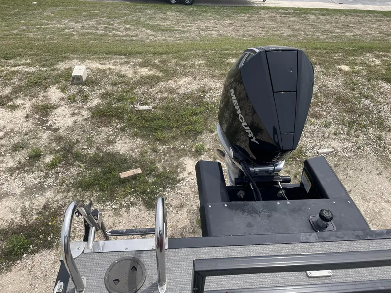 Slide: The Image of 2023 Regency 250DL3 boat with Mercury outboard motor on grassy terrain. - 18