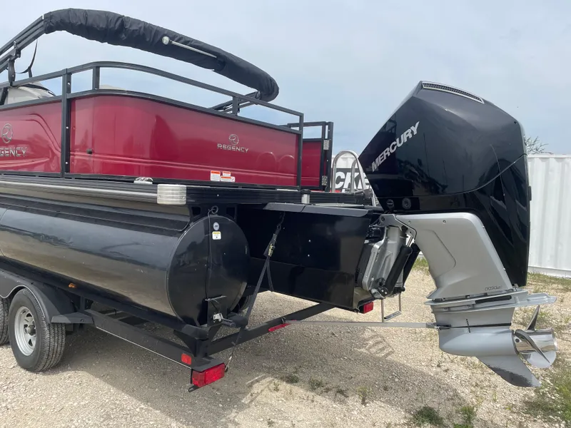 Slide: The Image of 2023 Regency 250DL3 pontoon boat with Mercury outboard motor on a trailer. - 2