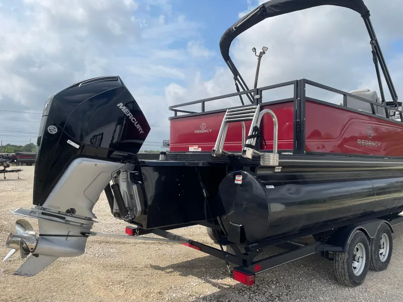 Slide: The Image of 2023 Regency 250DL3 pontoon boat with Mercury outboard motor, on a trailer. - 3