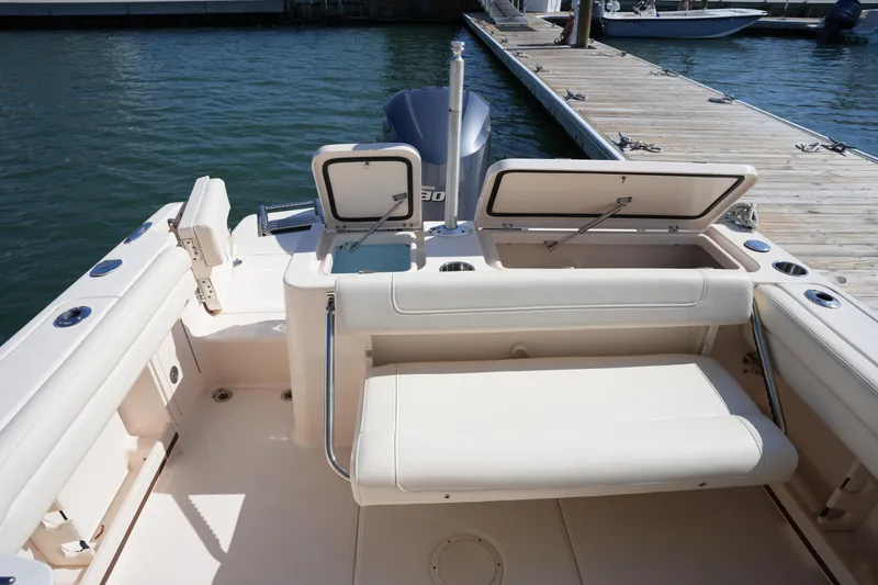 Slide: The Image of 2021 Grady-White Freedom 235 boat interior with seating and storage, docked by the water. - 16