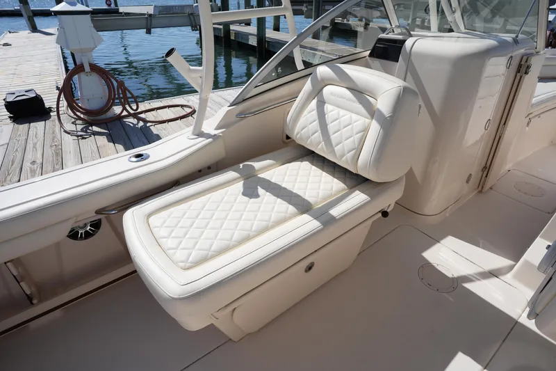 Slide: The Image of 2021 Grady-White Freedom 235 boat interior with white cushioned seating at dock. - 17