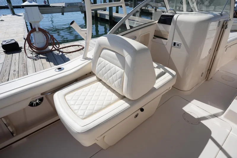 Slide: The Image of 2021 Grady-White Freedom 235 boat interior with cushioned seating at dock. - 18